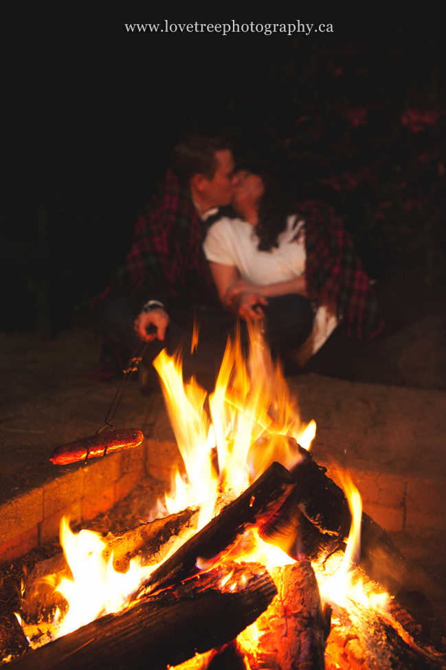 roasting hotdogs at a camping engagement session romantic and rustic country portrait session ; image by vancouver wedding photographer love tree photography