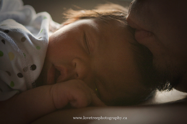 a newborn baby laying on her father's chest just a few hours after her birth; image by www.lovetreephotography.ca