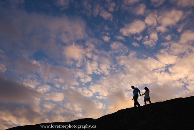 a couple set against a huge sky on the cliffs of west vancouver, shot by vancouver enagement photographers www.lovetreephotography.ca
