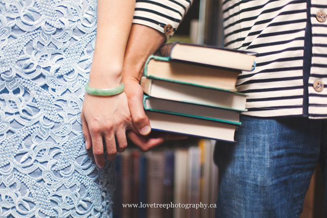 holding hands while holding books; image by award winning wedding photographer www.lovetreephotography.ca